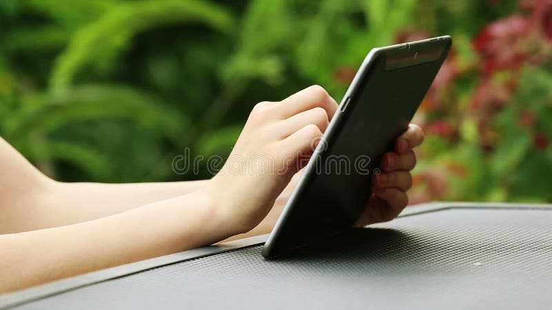 Fermez-vous des mains de femme utilisant la tablette dehors banque de vidéos