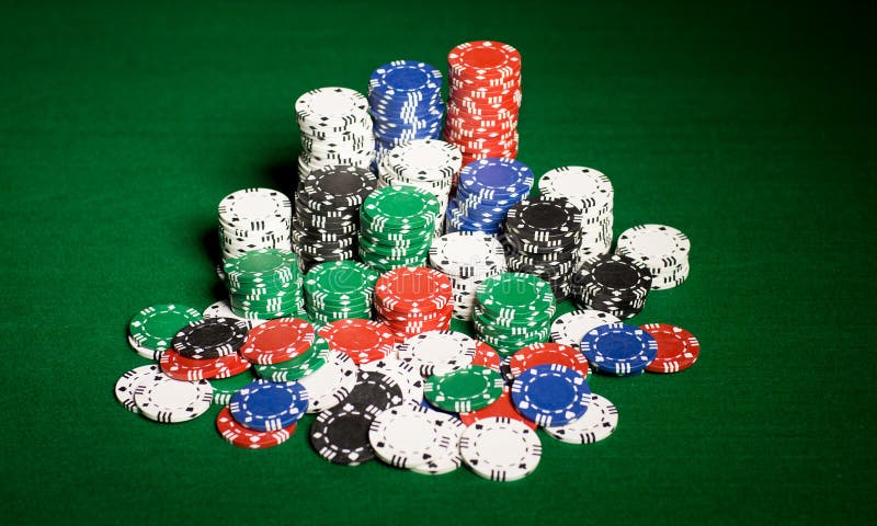 Fermez-vous des puces de casino sur la surface de table verte image libre de droits Fermez-vous des puces de casino sur la surface de table verte image libre de droits