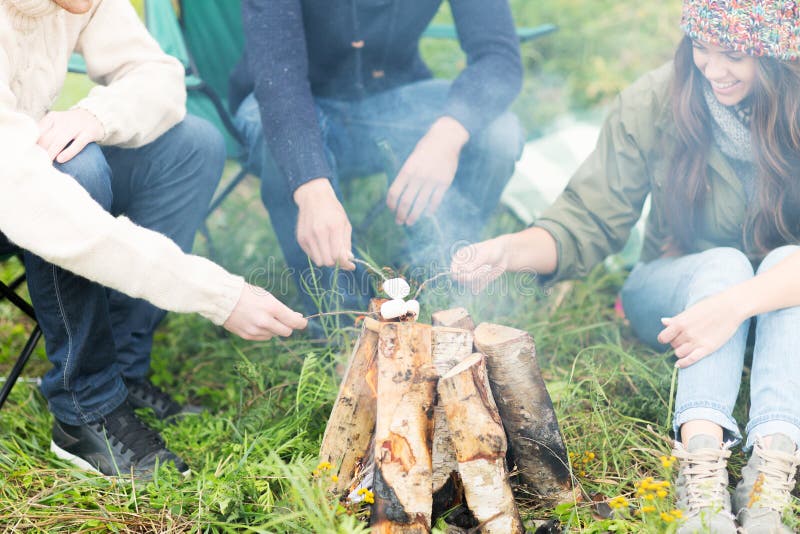 Fermez-vous des randonneurs rôtissant la guimauve sur le feu photos libres de droits Fermez-vous des randonneurs rôtissant la guimauve sur le feu photos libres de droits