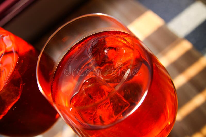 Fermez-vous du cocktail rouge avec des glaçons en verre de vin images stock Fermez-vous du cocktail rouge avec des glaçons en verre de vin images stock