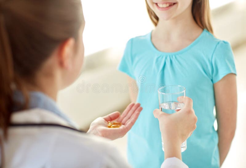 Fermez-vous du docteur donnant la médecine à la fille heureuse photo libre de droits Fermez-vous du docteur donnant la médecine à la fille heureuse photo libre de droits