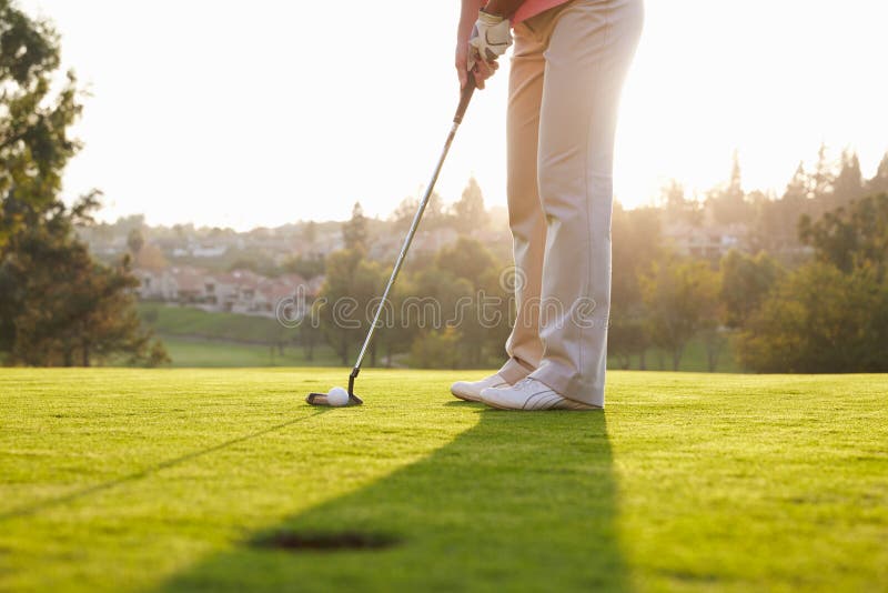 Fermez-vous du golfeur masculin alignant le putt sur le vert photos libres de droits Fermez-vous du golfeur masculin alignant le putt sur le vert photos libres de droits