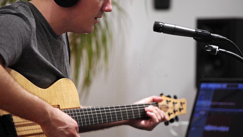 Fermez-vous du musicien chantant et jouant la guitare ?lectrique dans le studio ? la maison de musique