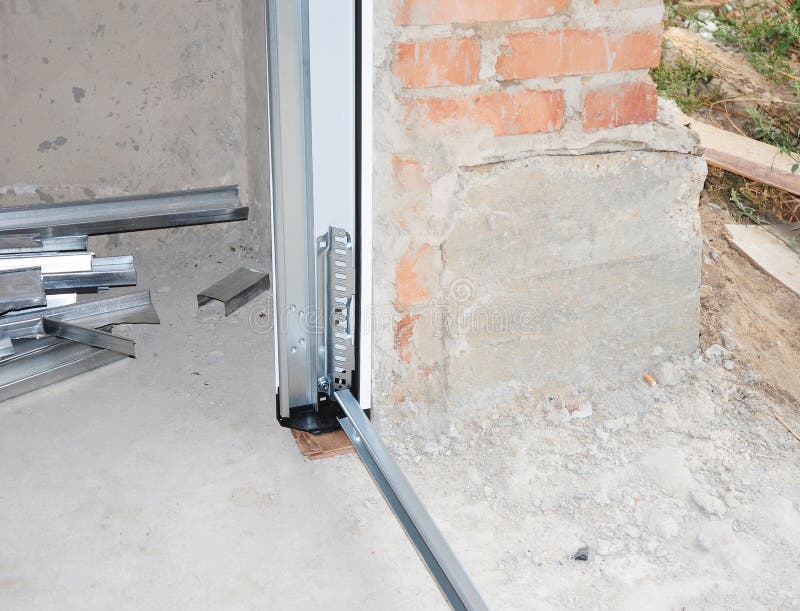 Fermez-vous sur installer la porte de garage Porte de garage photo libre de droits Fermez-vous sur installer la porte de garage Porte de garage photo libre de droits