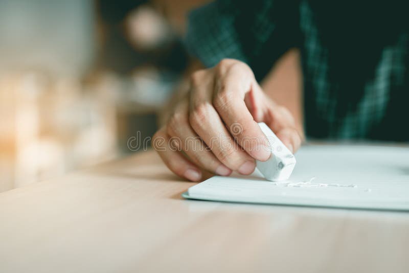Fermez-vous vers le haut de l'étudiant à l'aide de la gomme pour éditent l'erreur photos stock Fermez-vous vers le haut de l'étudiant à l'aide de la gomme pour éditent l'erreur photos stock