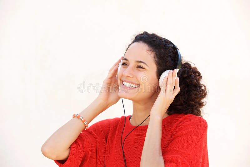 Fermez-vous vers le haut de la belle jeune femme écoutant la musique avec des écouteurs sur le fond blanc images stock Fermez-vous vers le haut de la belle jeune femme écoutant la musique avec des écouteurs sur le fond blanc images stock