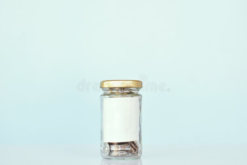 Fermez-vous vers le haut de la pièce de monnaie dans le pot en verre, concept épargnent l'argent image stock Fermez-vous vers le haut de la pièce de monnaie dans le pot en verre, concept épargnent l'argent image stock