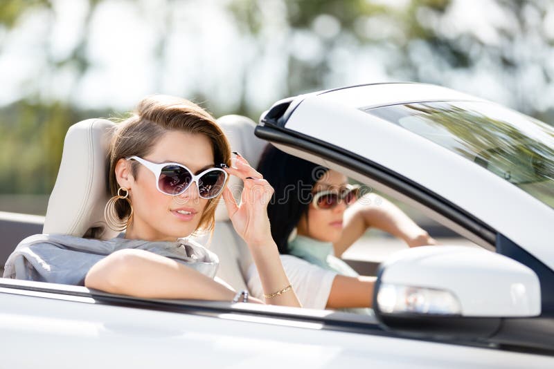 Close up view of girls wearing sunglasses in the automobile. Little holiday trip of friends. Close up view of girls wearing sunglasses in the automobile. Little holiday trip of friends