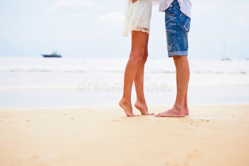 Fermez-vous vers le haut des pieds masculins et femelles sur le sable photographie stock Fermez-vous vers le haut des pieds masculins et femelles sur le sable photographie stock