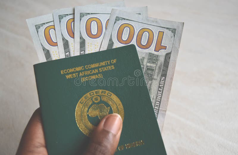Fermez-vous vers le haut du passeport nigérien avec la devise des dollars image libre de droits Fermez-vous vers le haut du passeport nigérien avec la devise des dollars image libre de droits