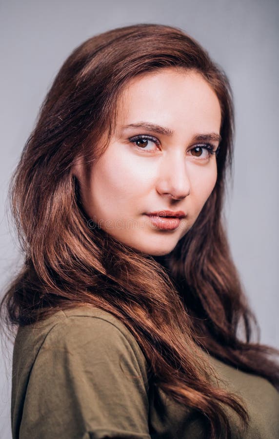 Fermez-vous vers le haut du portrait de la belle femme mignonne de brune sur le fond gris Émotions positives, expression du visag photo libre de droits Fermez-vous vers le haut du portrait de la belle femme mignonne de brune sur le fond gris Émotions positives, expression du visag photo libre de droits