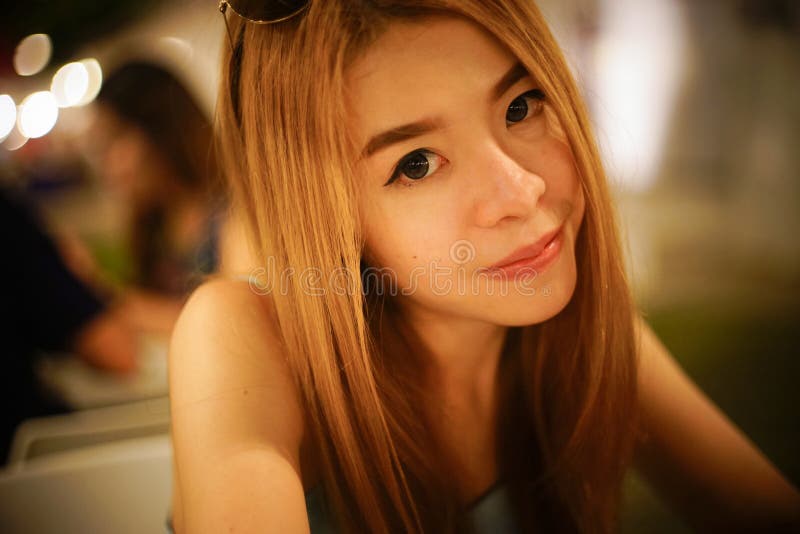 Fermez-vous vers le haut du portrait du jeune sourire asiatique et de regarder de femme l'appareil-photo avec le fond brouillé, f photographie stock libre de droits Fermez-vous vers le haut du portrait du jeune sourire asiatique et de regarder de femme l'appareil-photo avec le fond brouillé, f photographie stock libre de droits