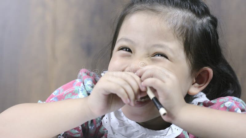 Fermez-vous vers le haut du sourire gai et du crayon de petite fille asiatique mignonne à disposition banque de vidéos