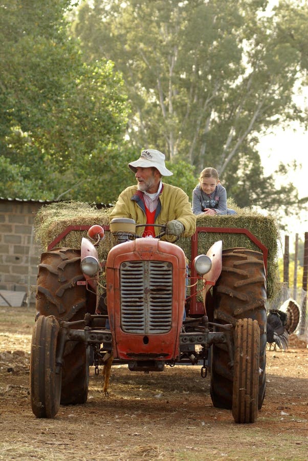 Grant-father and grant-daughter driving on tractor and wagon. Grant-father and grant-daughter driving on tractor and wagon.