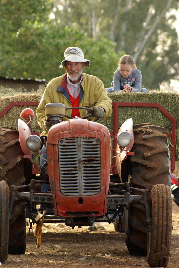 Grant-father and grant-daughter driving on tractor and wagon. Grant-father and grant-daughter driving on tractor and wagon.