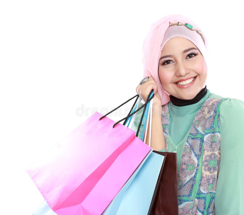 Fermé de la jeune femme musulmane heureuse avec le sac à provisions photographie stock Fermé de la jeune femme musulmane heureuse avec le sac à provisions photographie stock