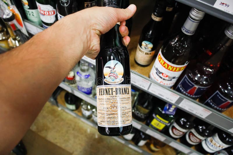 fernet-branca-una-mano-sostiene-botella-de-licor-en-exhibici%C3%B3n-un-supermercado-local-los-angele