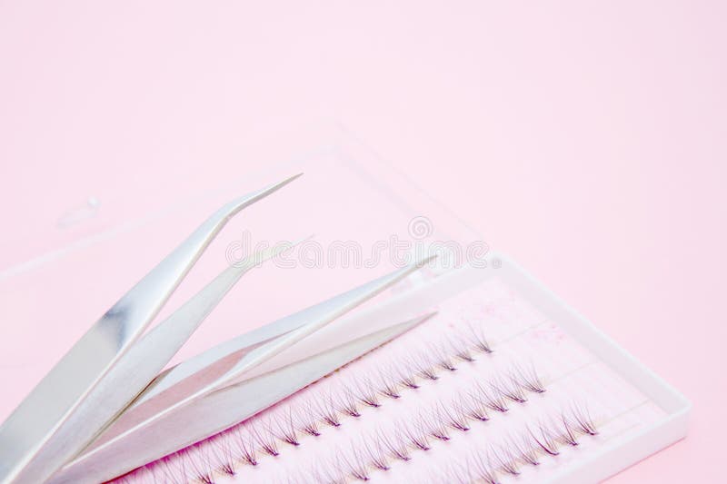 Beauty and fashion concept - tools for Eyelash Extension Procedure. Two tweezers and box with false lashes on pink background. copyspace mockup. Beauty and fashion concept - tools for Eyelash Extension Procedure. Two tweezers and box with false lashes on pink background. copyspace mockup