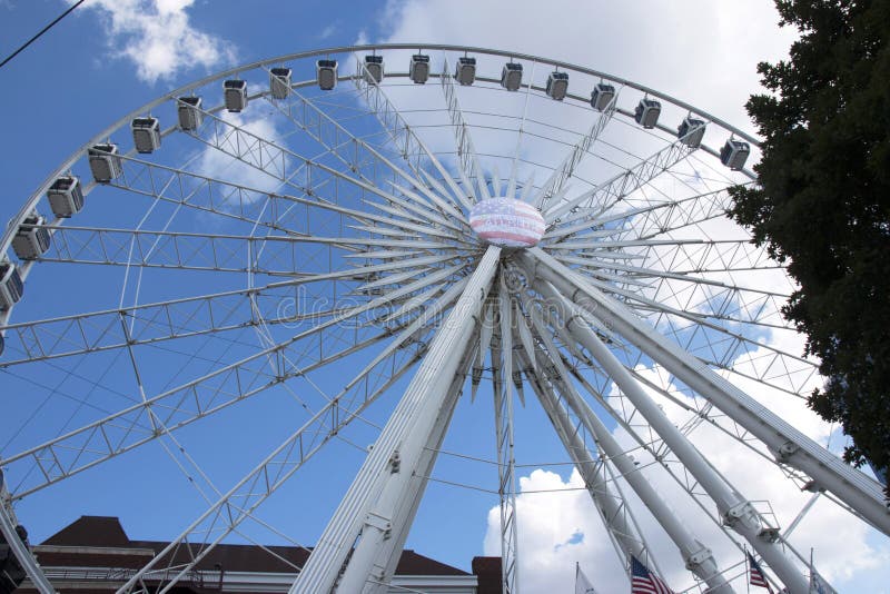 The ferris wheel in Atlanta Ga, with blue sky and white clouds in the background. The ferris wheel in Atlanta Ga, with blue sky and white clouds in the background