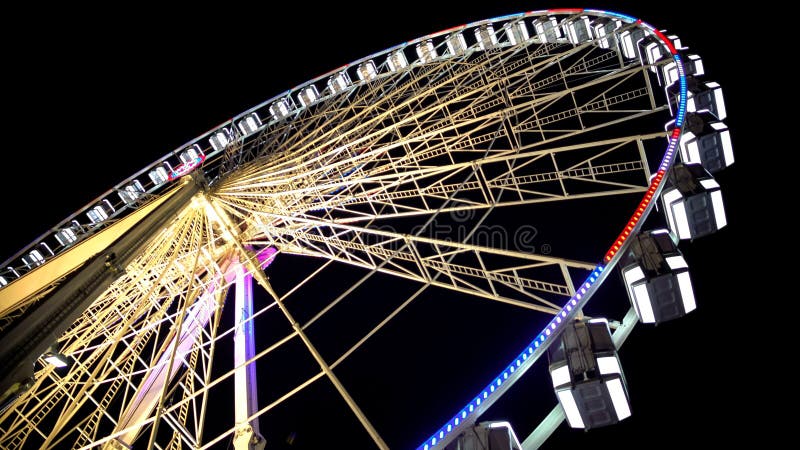 Ferris wheel at amusement park, colorful illuminated construction, bottom view stock photos Ferris wheel at amusement park, colorful illuminated construction, bottom view stock photos