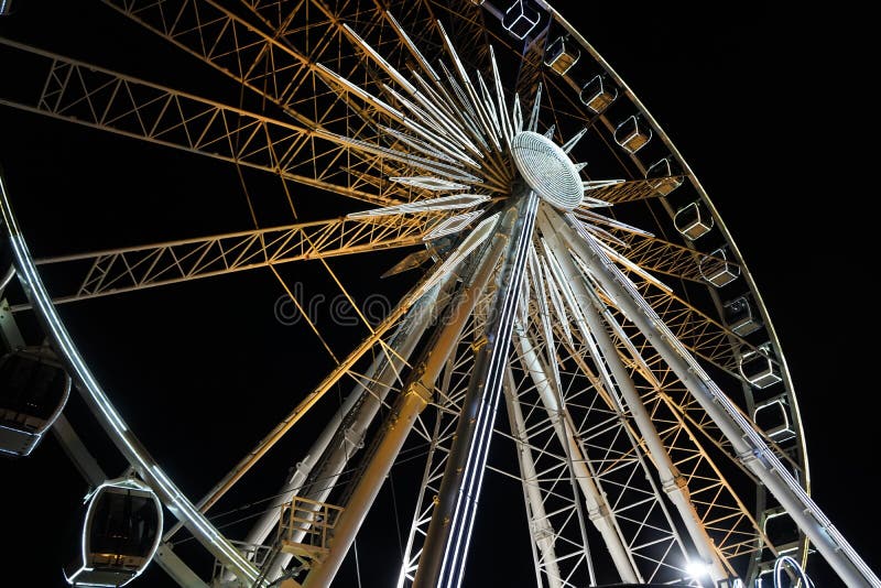 Ferris wheel. A ferris wheel rotates against the background of the night sky. Close-up of a Ferris wheel with night illumination