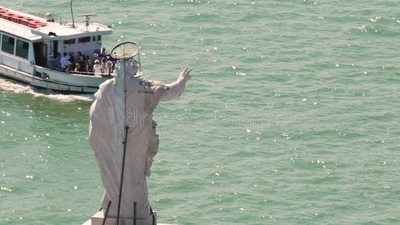 Ferry de touristes allant à travers la rivière passant la statue d'un saint, visite guidée banque de vidéos