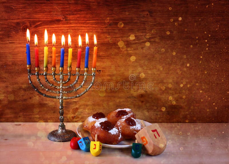 Jewish holiday Hanukkah with menorah, doughnuts over wooden table. retro filtered image. Jewish holiday Hanukkah with menorah, doughnuts over wooden table. retro filtered image.