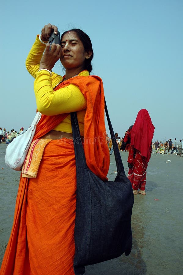 January 14, 2009-Ganga sagar, West Bengal, India - A HINDU WOMAN WITH A TRADITIONAL DRESS TAKING SNAP TO HER ANCESTORS AT THE FAIR GROUND OF GANGA SAGAR. Gangasagar Mela is the largest fair, celebrated in West Bengal (INDIA). This fair is held where the Ganga river and the Bay of Bengal form a nexus. Hence the name Gangasagar Mela. This festival is celebrated during mid January every year and is a major attraction for millions of pilgrims from different parts of the country gather at Gangasagar, the point where the holy river Ganges meets the sea to take a dip and wash away all the earthly sins. January 14, 2009-Ganga sagar, West Bengal, India - A HINDU WOMAN WITH A TRADITIONAL DRESS TAKING SNAP TO HER ANCESTORS AT THE FAIR GROUND OF GANGA SAGAR. Gangasagar Mela is the largest fair, celebrated in West Bengal (INDIA). This fair is held where the Ganga river and the Bay of Bengal form a nexus. Hence the name Gangasagar Mela. This festival is celebrated during mid January every year and is a major attraction for millions of pilgrims from different parts of the country gather at Gangasagar, the point where the holy river Ganges meets the sea to take a dip and wash away all the earthly sins.