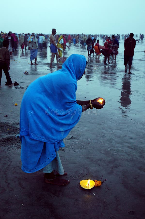 January 14, 2009-Ganga sagar, West Bengal, India -A HINDU WOMAN PRAYING TO THE SUN GOD WITH MAKE LIGHT A FIRE. Gangasagar Mela is the largest fair, celebrated in West Bengal (INDIA). This fair is held where the Ganga river and the Bay of Bengal form a nexus. Hence the name Gangasagar Mela. This festival is celebrated during mid January every year and is a major attraction for millions of pilgrims from different parts of the country gather at Gangasagar, the point where the holy river Ganges meets the sea to take a dip and wash away all the earthly sins. January 14, 2009-Ganga sagar, West Bengal, India -A HINDU WOMAN PRAYING TO THE SUN GOD WITH MAKE LIGHT A FIRE. Gangasagar Mela is the largest fair, celebrated in West Bengal (INDIA). This fair is held where the Ganga river and the Bay of Bengal form a nexus. Hence the name Gangasagar Mela. This festival is celebrated during mid January every year and is a major attraction for millions of pilgrims from different parts of the country gather at Gangasagar, the point where the holy river Ganges meets the sea to take a dip and wash away all the earthly sins.