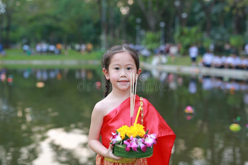 Festival di Loy Krathong, ragazza asiatica del bambino in vestito tradizionale tailandese con il krathong della tenuta per la dea fotografie stock Festival di Loy Krathong, ragazza asiatica del bambino in vestito tradizionale tailandese con il krathong della tenuta per la dea fotografie stock