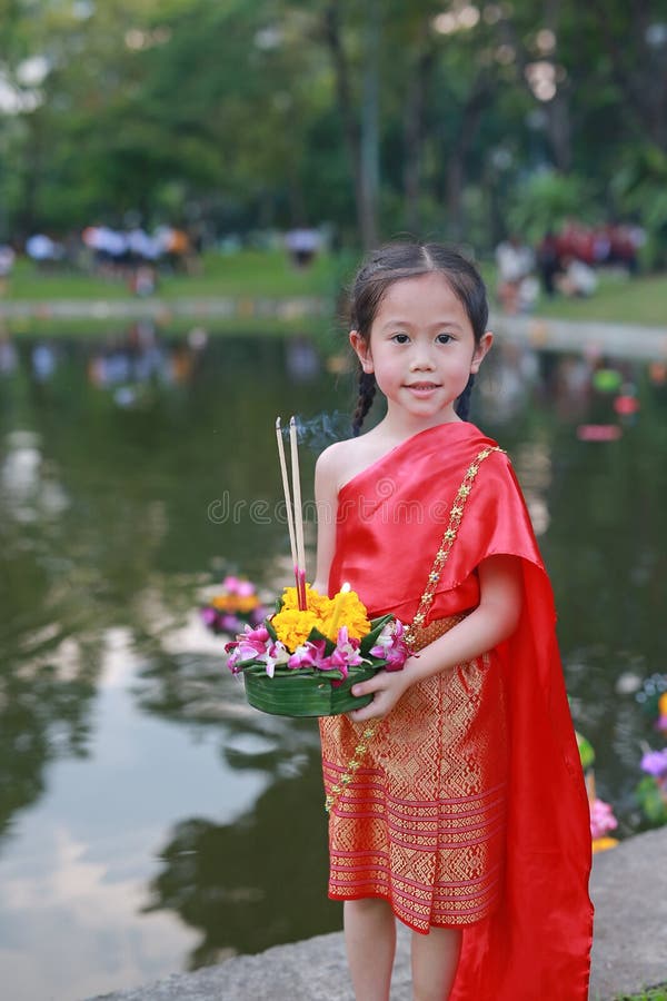 Festival di Loy Krathong, ragazza asiatica del bambino in vestito tradizionale tailandese con il krathong della tenuta per la dea fotografie stock Festival di Loy Krathong, ragazza asiatica del bambino in vestito tradizionale tailandese con il krathong della tenuta per la dea fotografie stock
