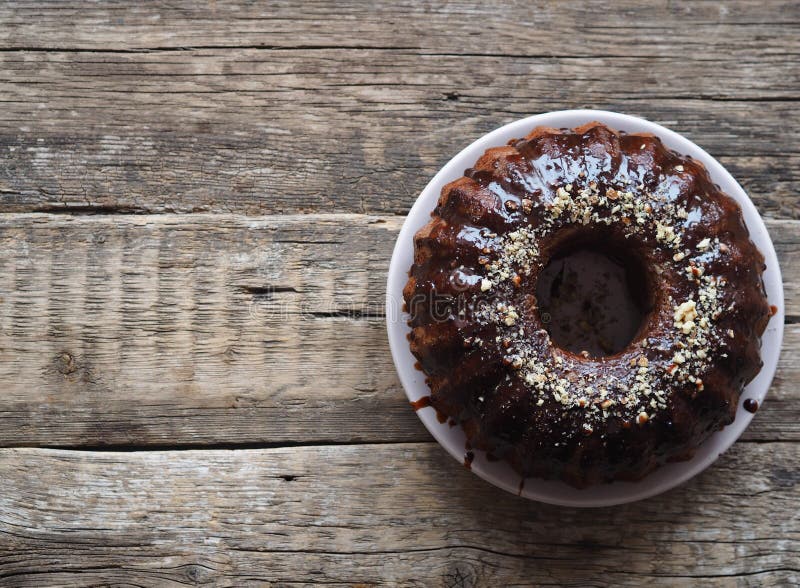 Festive homemade cakes. Round chocolate muffin, large biscuit or cake with chocolate icing on an ancient wooden background. Place