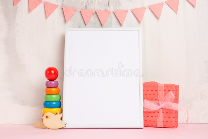 Festive mood, children`s garland with a white empty frame for design, and toys with gift layout. Baby shower,