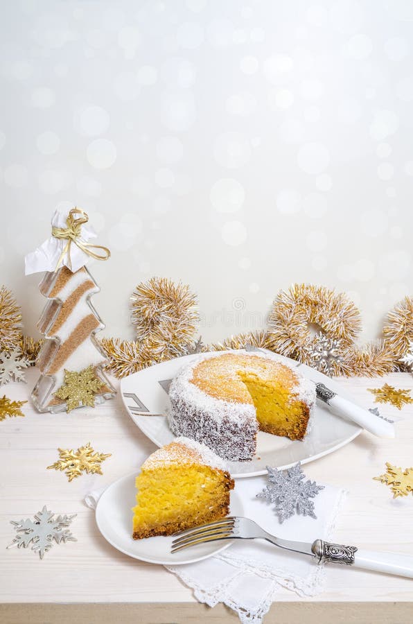 Festive pumpkin cake with coconut on table and Christmas decoration. Background bokeh