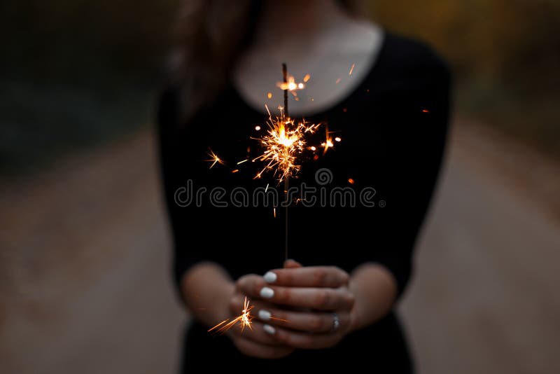 Festive sparkler. Women`s hands hold a bright sparkler royalty free stock photography Festive sparkler. Women`s hands hold a bright sparkler royalty free stock photography