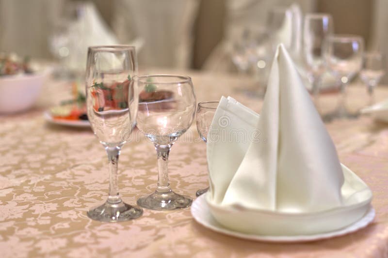 Festive table setting, folded napkin on a plate and three glasses for various drinks stock images Festive table setting, folded napkin on a plate and three glasses for various drinks stock images