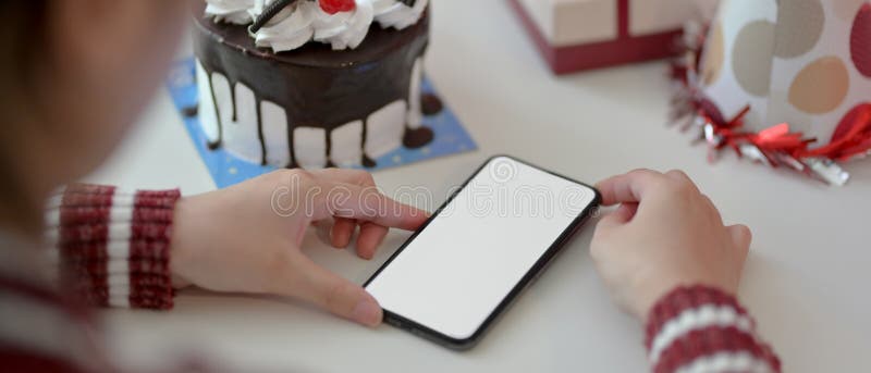 Festività di compleanno online femminile con smartphone bianco su tavolo bianco fotografie stock