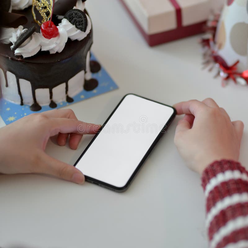 Festività di compleanno online femminile con smartphone bianco su tavolo bianco fotografia stock libera da diritti
