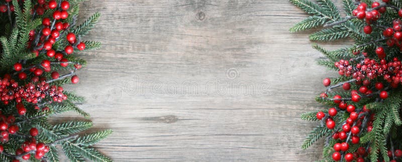 Festività di natale branche di pino sempreverde confine e bacche rosse cornice di fondo legno spazio immagine stock Festività di natale branche di pino sempreverde confine e bacche rosse cornice di fondo legno spazio immagine stock