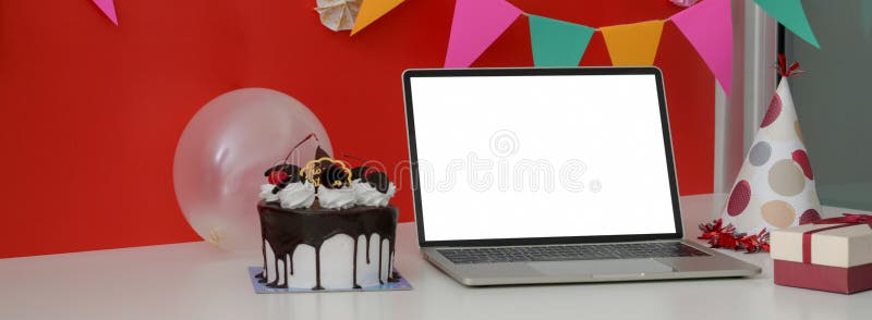 Festività online con torta di compleanno a schermo bianco e palloncino su tavolo bianco fotografia stock libera da diritti