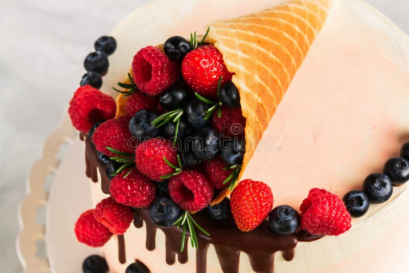 Festlicher Kuchen mit schmelzender Schokolade und sortierten Früchten in einem Waffelhorn auf neutralem Hintergrund stockbilder Festlicher Kuchen mit schmelzender Schokolade und sortierten Früchten in einem Waffelhorn auf neutralem Hintergrund stockbilder