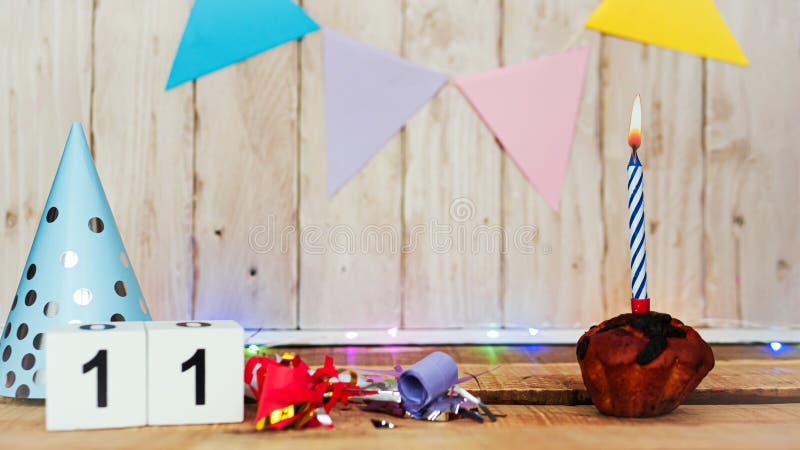 Festive Happy birthday background with number or digit 11. Postcard with a muffin and burning candles. Festive copy space background. Festive Happy birthday background with number or digit 11. Postcard with a muffin and burning candles. Festive copy space background