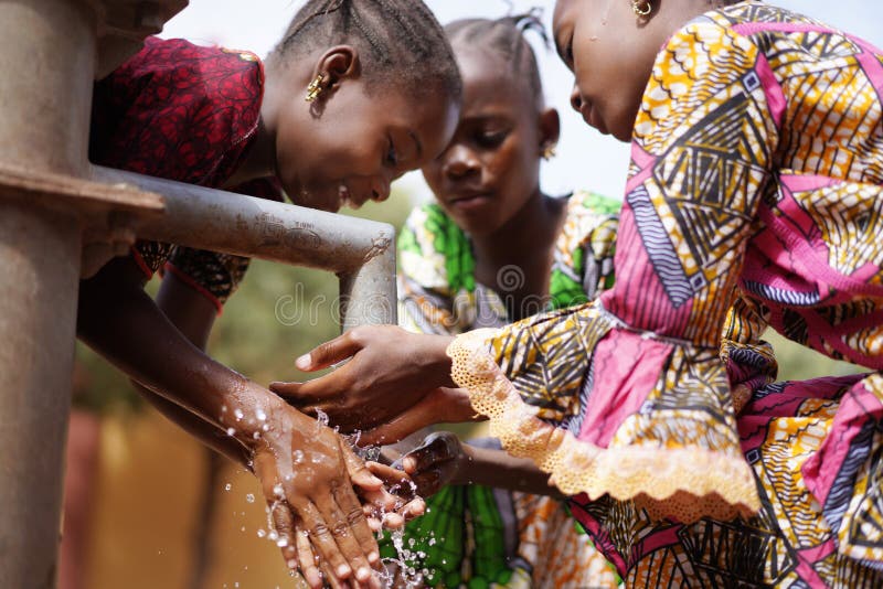 Fete africane superbe care spală mâini sub apă în exterior stock photos