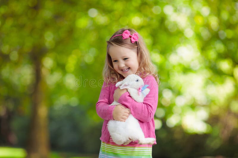 Fetiță care se joacă cu iepurele stock image