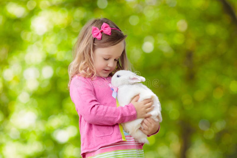 Fetiță care se joacă cu iepurele royalty free stock image