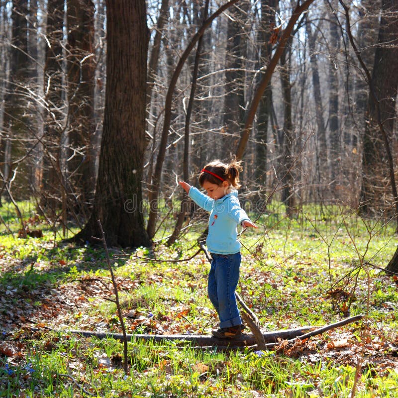 Fetiță care se joacă în pădure stock image