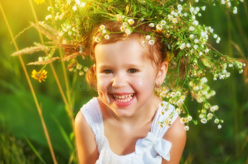 Fetiță veselă și veselă într-o coroană pe natură care râde vara royalty free stock photo