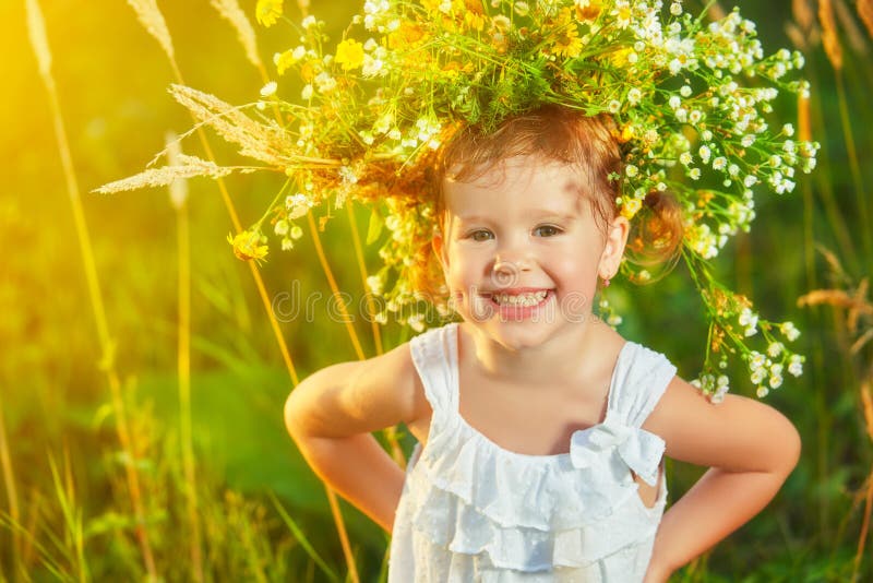 Fetiță veselă și veselă într-o coroană pe natură care râde vara stock photo