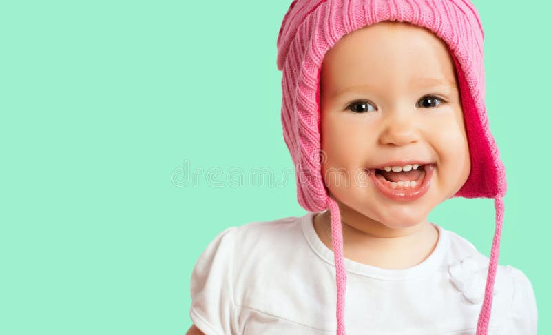 Fetiță veselă și veselă într-o iarnă roz, tricotată râzând royalty free stock photography