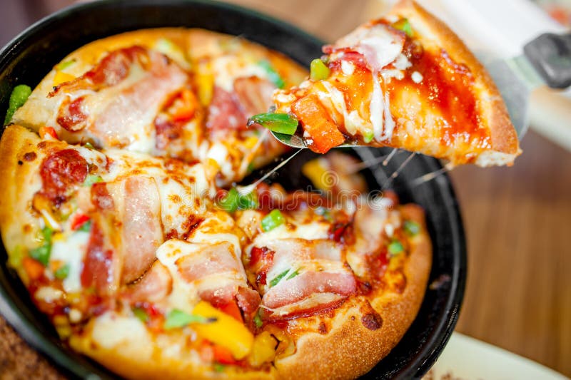 Fetta del cannibale di pizza calda con bacon extra, il prosciutto e le verdure